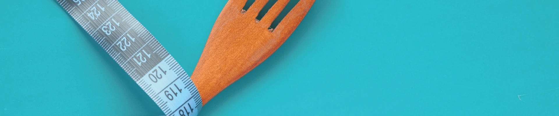 Cinta métrica y tenedor de madera - fondo slider DY - Las claves para adelgazar durante la menopausia sin dietas restrictivas