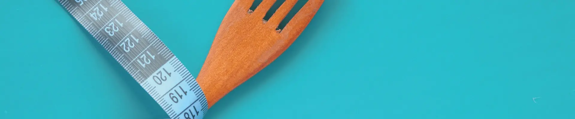 Cinta métrica y tenedor de madera - fondo slider DY - Las claves para adelgazar durante la menopausia sin dietas restrictivas